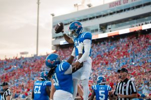 Ole Miss left tackle Diego Pounds lifting quarterback Trinidad Chambliss in the air after a touchdown drive. (Photo from Blake Harrell/SuperTalk Mississippi News)